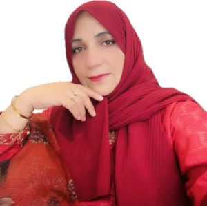 A woman in a headscarf poses for a photo, resting her chin on her hand.