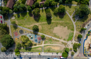 Aerial view of green space, roads, and homes