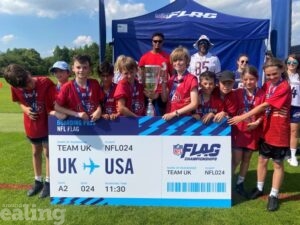 group of young pupils holding an oversized plane ticket