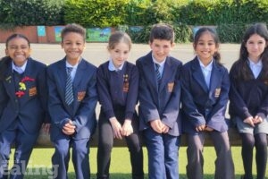 primary school children sitting outdoors on a bench