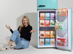 Kathryn, woman sitting next to a blue fridge