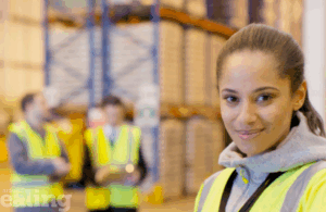 People of different ethnicity in a warehouse wearing high visibility vests