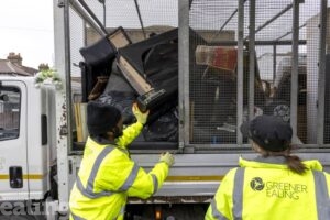 2 members of Greener Ealing loading a fly-tip onto a van