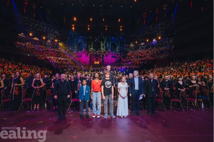 A group of schoolchildren standing alongside Michael Rosen at the Royal Albert Hall
