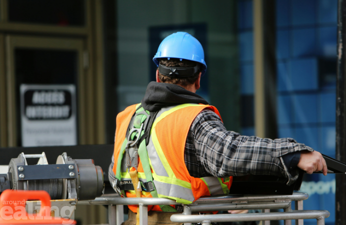 A man with safety hat and high visibility vest working in construction