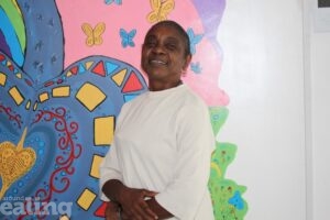 Anne-Marie Waugh, founder and CEO of RollaDome All Skate, in front of a colourful mural