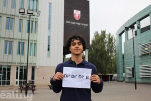 Sherwin Farahzadeh holding up his results at Brentside High School