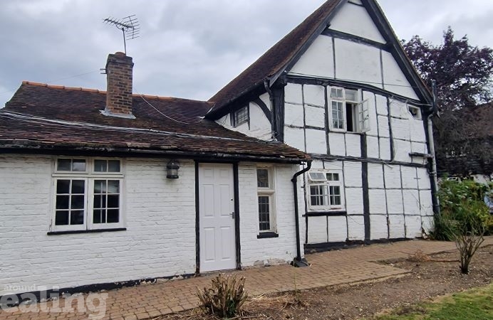 Outside of The Barn Hotel - white 2 floor building with a brown roof