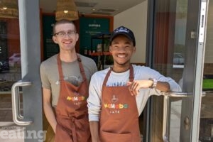A photo of Harrison and Ben, two staff members, with their Mahaba Cafe aprons on