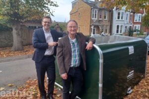 Council Leader Peter Mason and cabinet member for climate action, Paul Driscoll, stood leaning against a green bike hangar