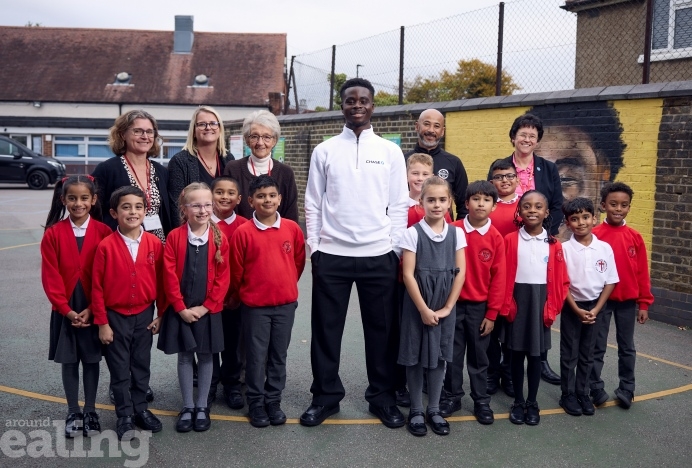Footballer Bukayo Saka visiting Edward Betham Primary - his old school - surrounded by pupils and teaching staff