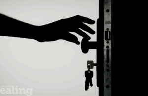 Hand reaching for a door with a key in it