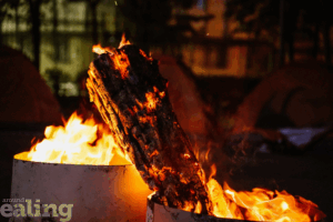 A burning log in a container surrounded by flames