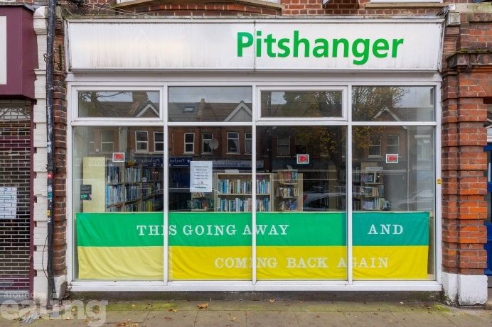 A photo of a sign that reads "This going away and coming back again." The text is white against a green and yellow background.