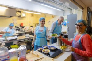 volunteers in soup kitchen dishing up meals