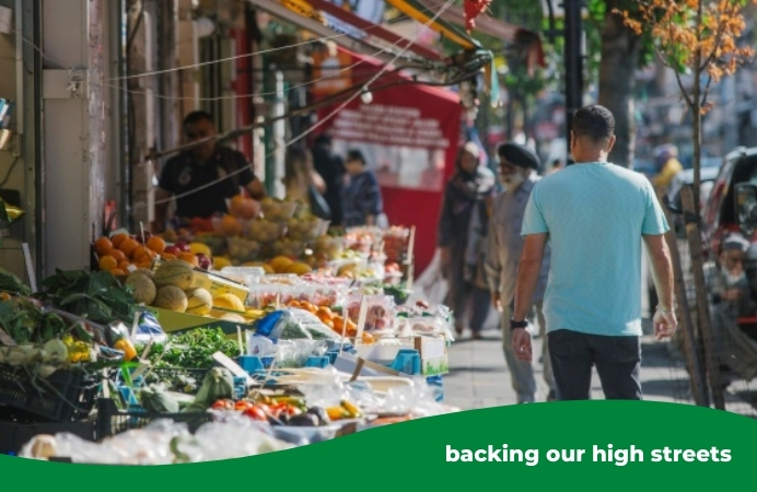 Shopping in Southall: a fruit stall and shoppers walking by