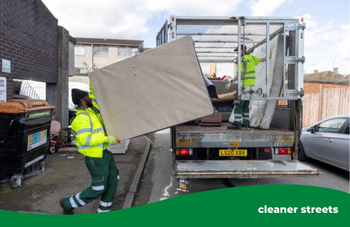 Greener Ealing operative lifting a mattress onto a fly-tip caged vehicle