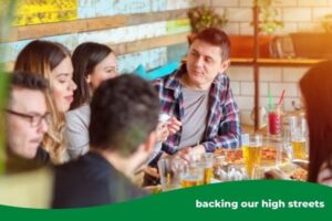 a group of men and women eating and drinking in a restaurant setting