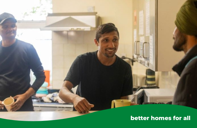 Man behind a counter talking to another man