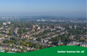 Drone shot of the borough with trees, houses and a blue sky