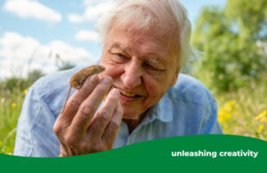Man smiling, with a small mouse climbing on his outstretched hand