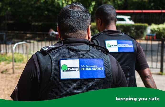 the back of 2 Parkguard officers on patrol outside near a park