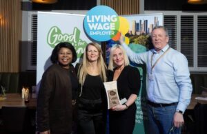 Group of people holding a 'Living Wage employer' sign