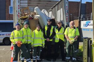 Greener Ealing Limited crew wearing high-visibility jackets, stood in front of a loaded refuse collection vehicle