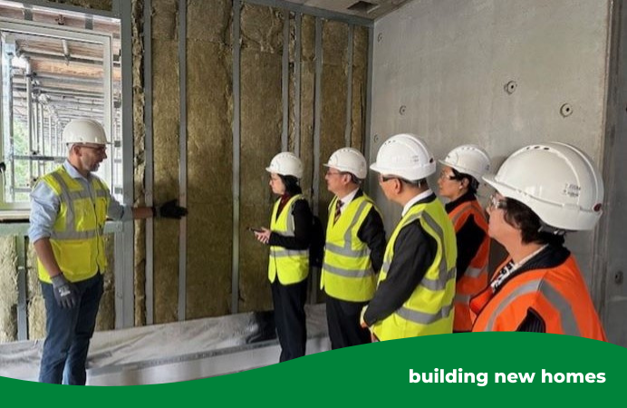 people standing with construction hats and vests on