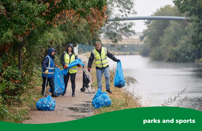 A group of people with litter pickers and refuse bags on a canal path.