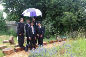 Five school children standing in a garden in the school's grounds