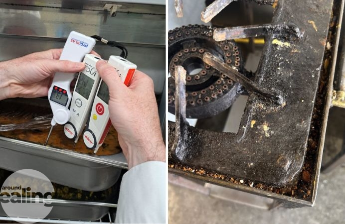 A hand holding three thermometers in a dish of food and a dirty gas hob
