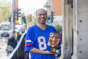 man holding BAFTA award
