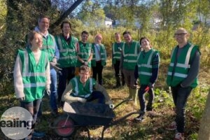 A group of volunteers outdoors in woodland with gardening equipment