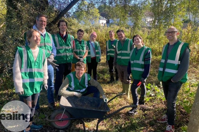 A group of volunteers outdoors in woodland with gardening equipment