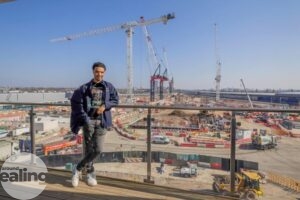 young man leaning on guardrail overlooking HS2 site