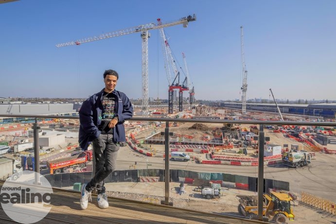 young man leaning on guardrail overlooking HS2 site