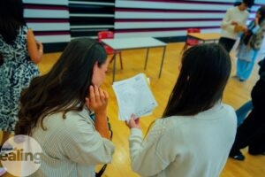 A student showing a member of staff her GCSE results at Dormer's Wells High School