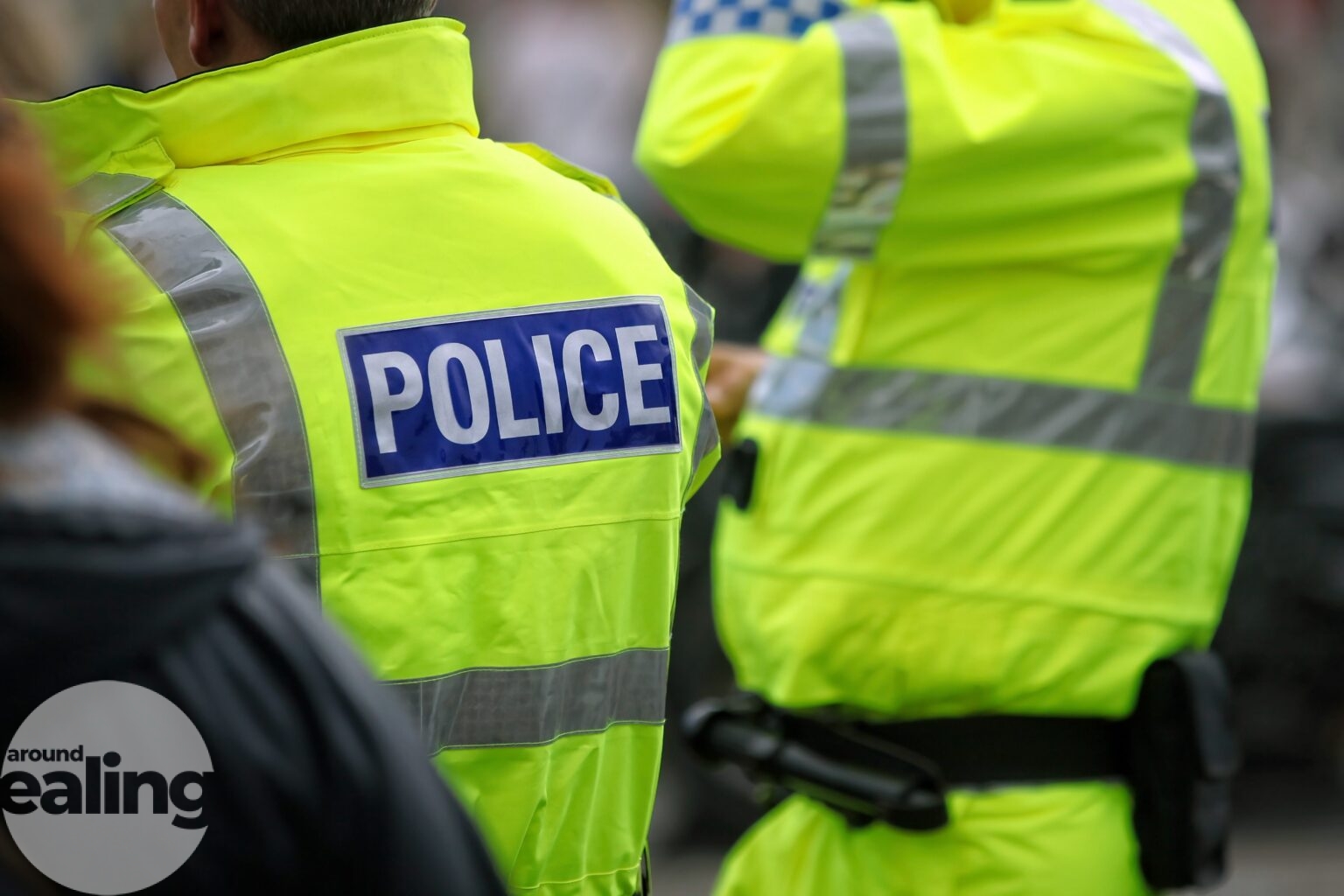 Two police officers in high vis with their backs to the camera